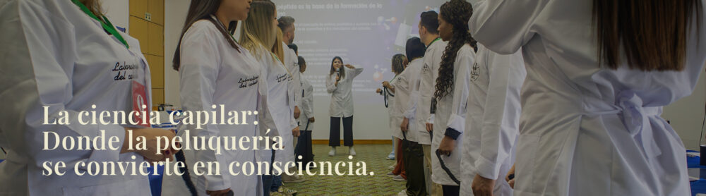 Angela Messa enseñando ciencia capilar a un grupo de profesionales de la belleza en batas blancas durante un evento presencial de MundoBIGcorp, laboratorio del cabello. La ciencia capilar: Donde la peluquería se convierte en consciencia.